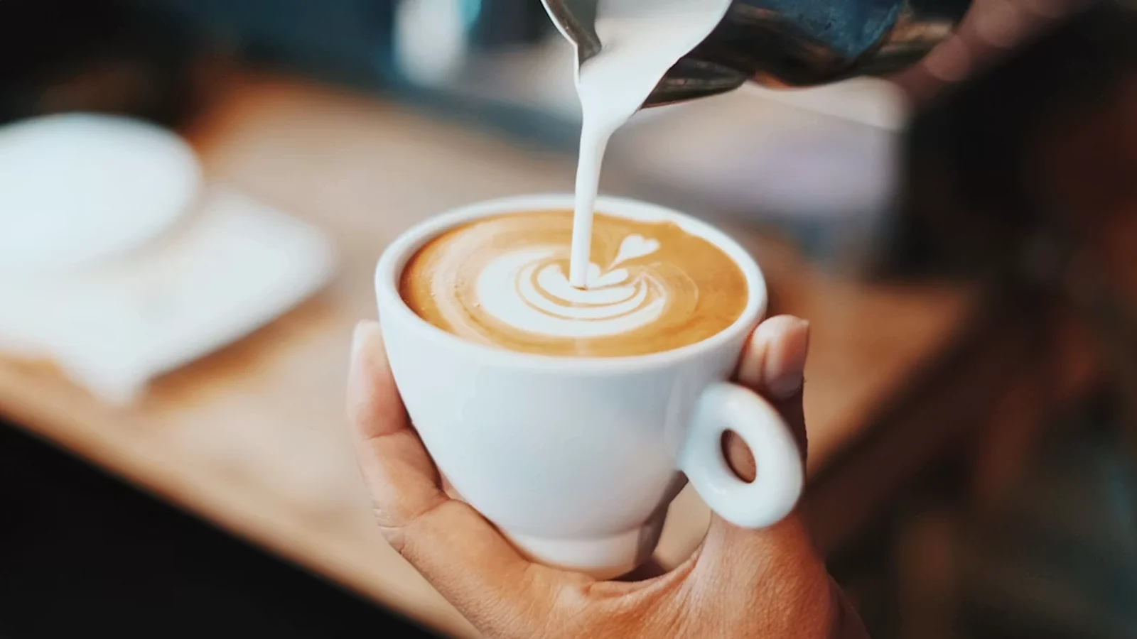 Café com latte art sendo preparado na cafeteria Dolce Biscotto